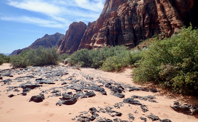The Red Sands Trail is what it says it is. The black rock must be lava.
